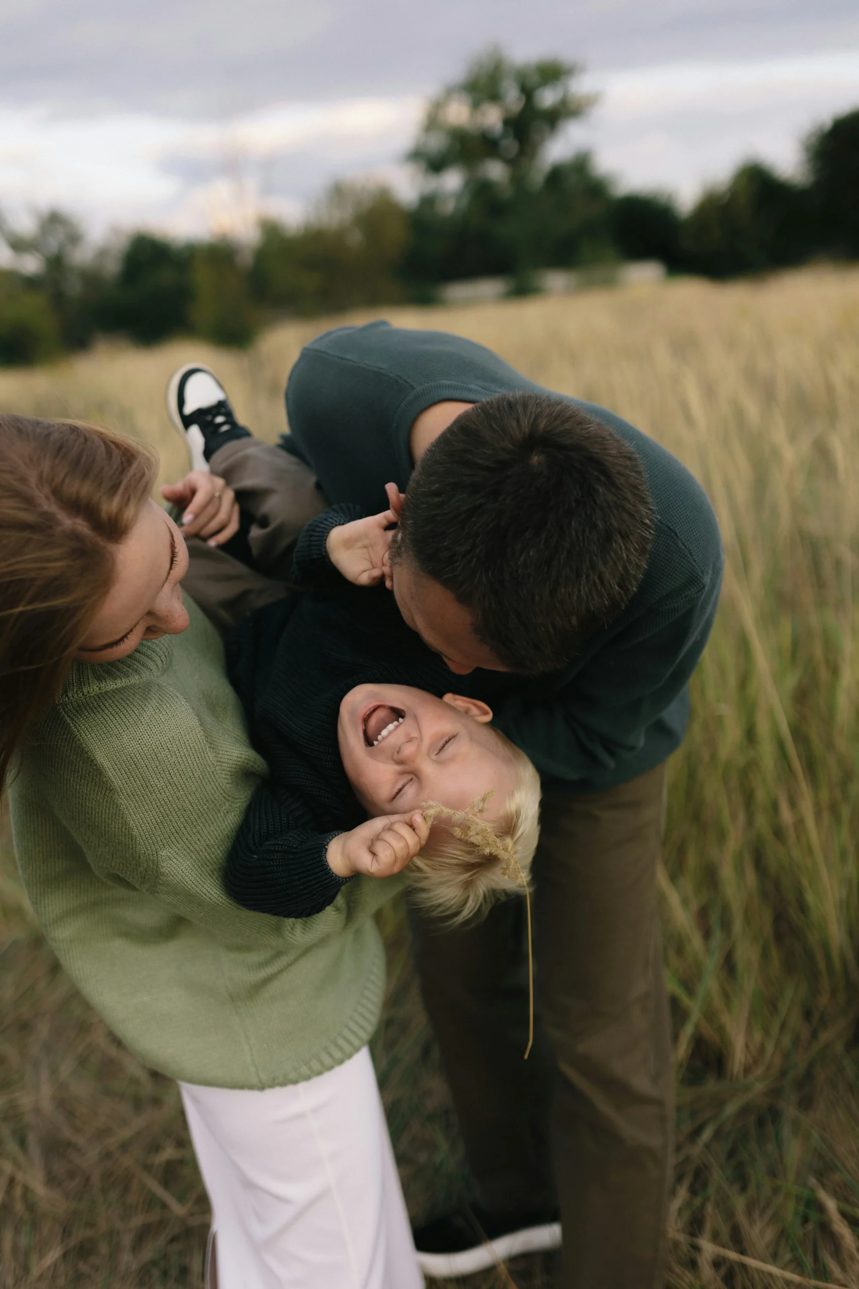 Couple de parents amoureux et heureux jouant avec leur enfant